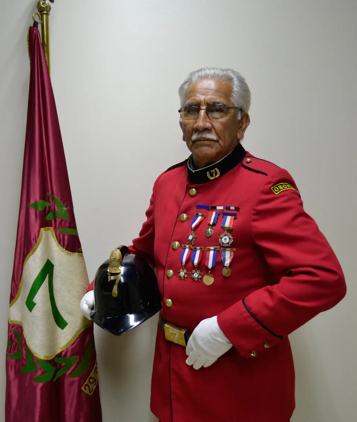 Juan Juvenal Cáceres Novoa con uniforme de gala, casco y condecoraciones bomberiles