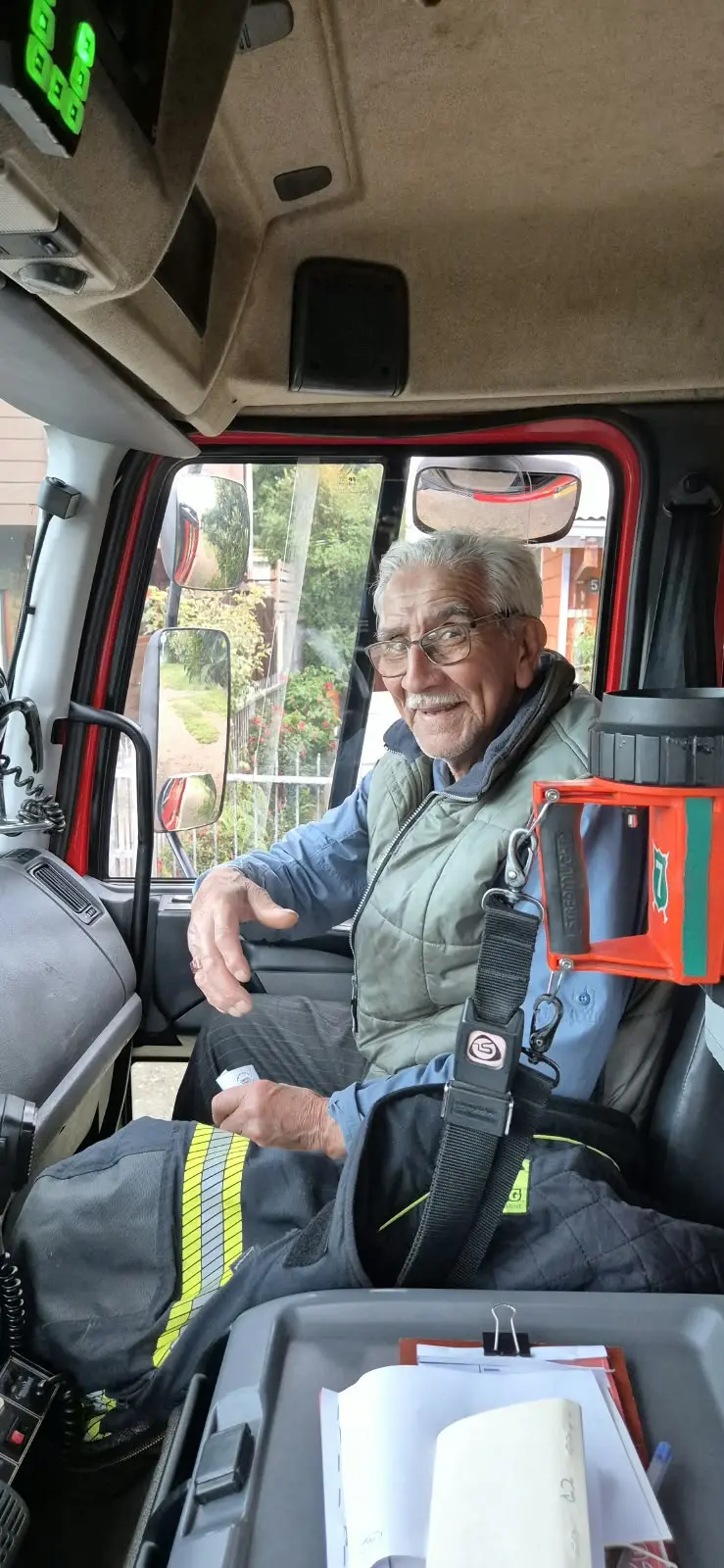 Juan Juvenal Cáceres Novoa sentado en la cabina de un móvil de bomberos
